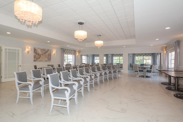 dining space featuring a chandelier, a raised ceiling, and crown molding