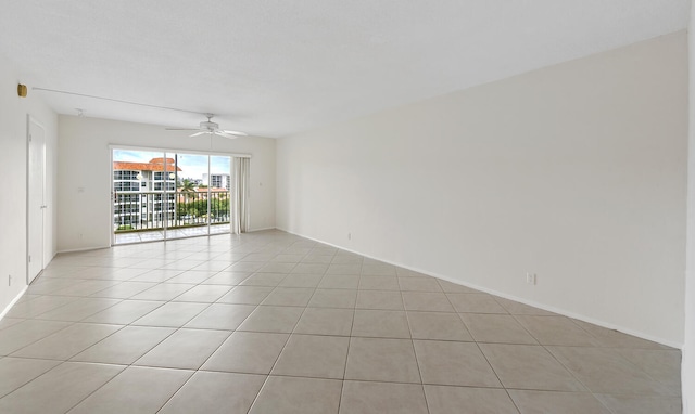 empty room featuring ceiling fan and light tile patterned floors