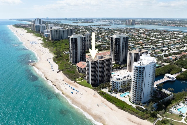 birds eye view of property with a water view and a beach view