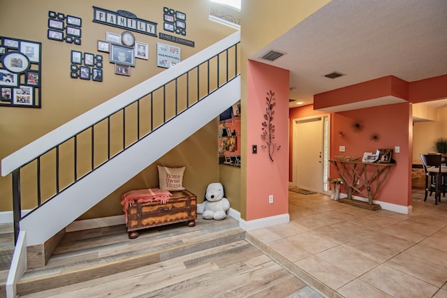 stairway featuring hardwood / wood-style flooring and a textured ceiling