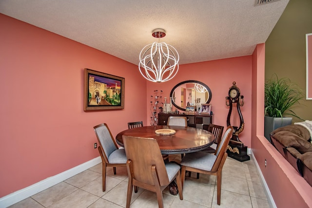 dining area with a notable chandelier, light tile patterned floors, and a textured ceiling