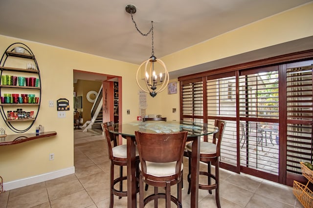 tiled dining room with an inviting chandelier