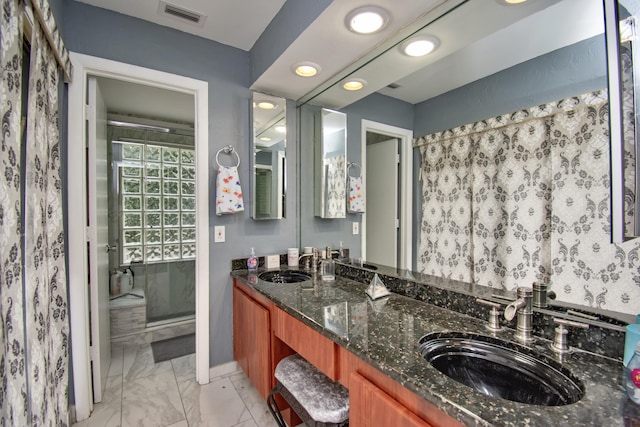 bathroom with vanity and a shower with door