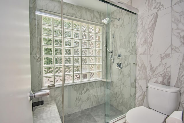 bathroom featuring walk in shower, toilet, and tile walls