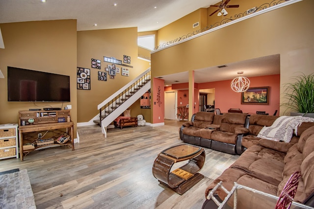 living room featuring ceiling fan, high vaulted ceiling, and light hardwood / wood-style floors