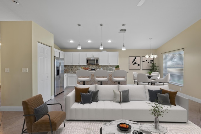 tiled living room with vaulted ceiling and a notable chandelier