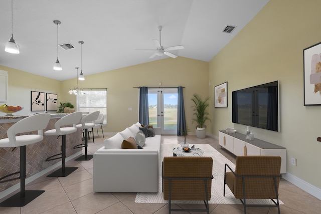 tiled living room featuring ceiling fan, vaulted ceiling, and french doors