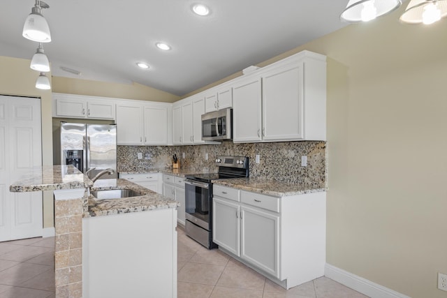 kitchen with white cabinetry, appliances with stainless steel finishes, a kitchen island with sink, decorative light fixtures, and sink