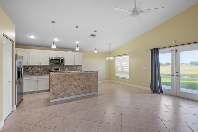 kitchen with white cabinetry, stainless steel appliances, backsplash, decorative light fixtures, and lofted ceiling