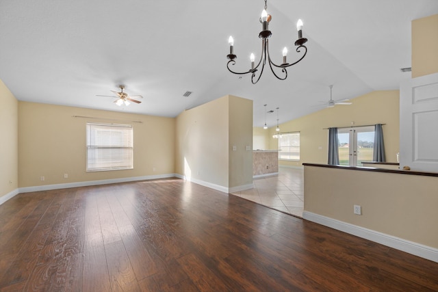 spare room with ceiling fan with notable chandelier, a wealth of natural light, and light hardwood / wood-style flooring