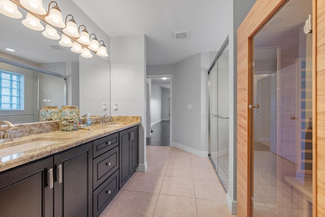 bathroom featuring walk in shower, vanity, and tile patterned flooring