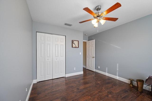 unfurnished bedroom with ceiling fan, dark hardwood / wood-style floors, and a closet