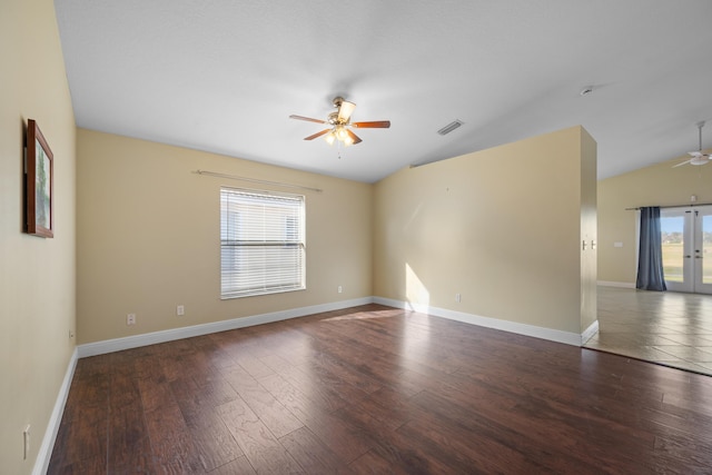 spare room featuring ceiling fan, dark wood-type flooring, vaulted ceiling, and a healthy amount of sunlight