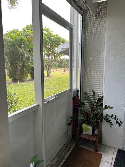 doorway to outside with light tile patterned floors