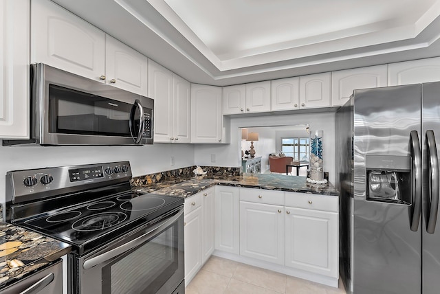 kitchen with white cabinets, a raised ceiling, and appliances with stainless steel finishes