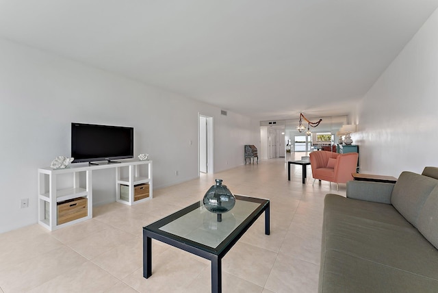 tiled living room featuring an inviting chandelier