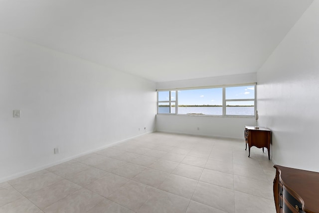 tiled spare room with a water view