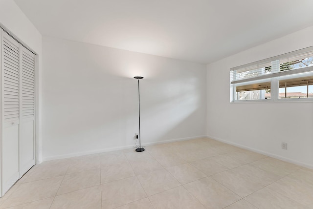 unfurnished bedroom with light tile patterned flooring and a closet