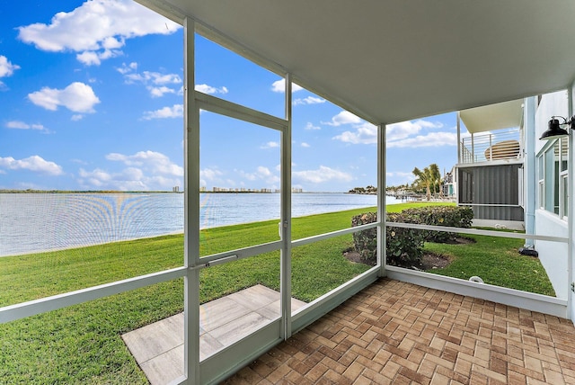 unfurnished sunroom featuring a water view