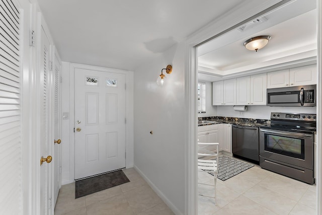 kitchen with white cabinets, light tile patterned floors, and stainless steel appliances