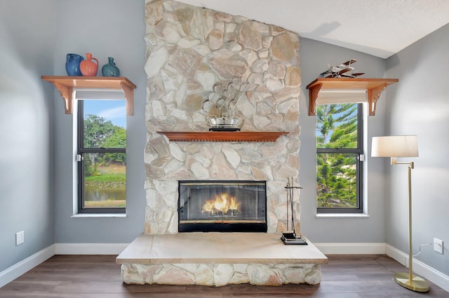 interior details with a fireplace, a textured ceiling, and hardwood / wood-style flooring