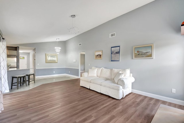 living room featuring high vaulted ceiling and hardwood / wood-style flooring