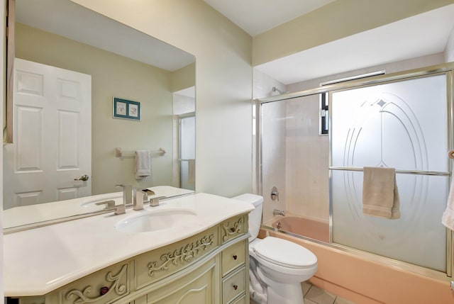 full bathroom with toilet, vanity, tile patterned floors, and bath / shower combo with glass door