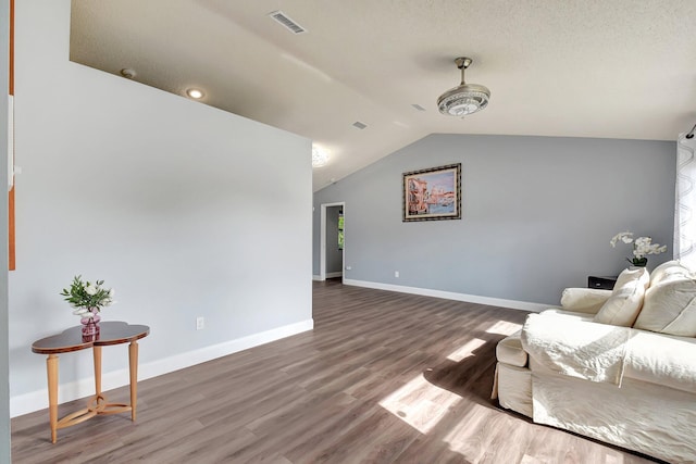 living area featuring dark hardwood / wood-style floors, lofted ceiling, and a textured ceiling