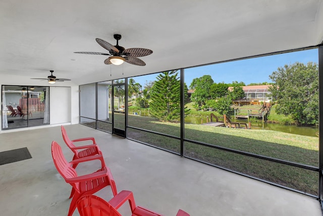 sunroom / solarium featuring a water view and ceiling fan