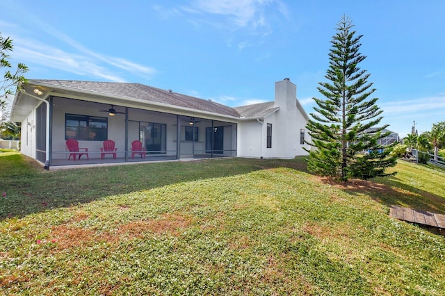 back of house with a lawn, a sunroom, and ceiling fan