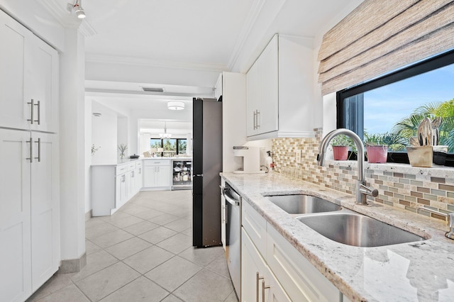 kitchen with tasteful backsplash, light stone counters, stainless steel appliances, sink, and white cabinets