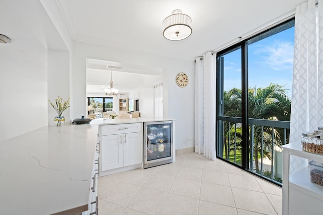 kitchen featuring white cabinets, a healthy amount of sunlight, hanging light fixtures, and wine cooler