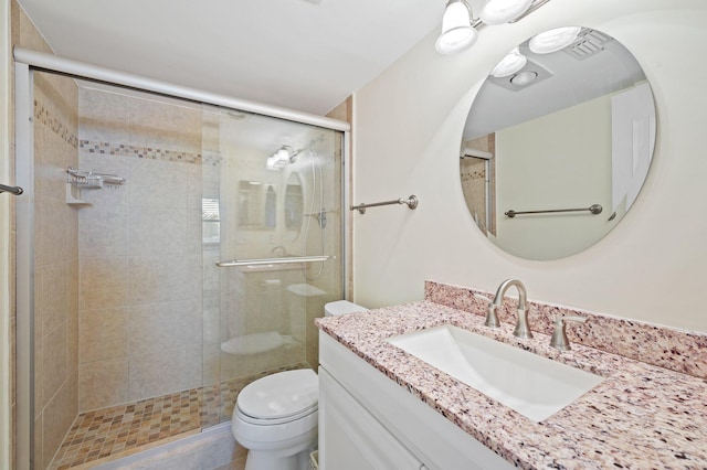 bathroom with vanity, an enclosed shower, and toilet