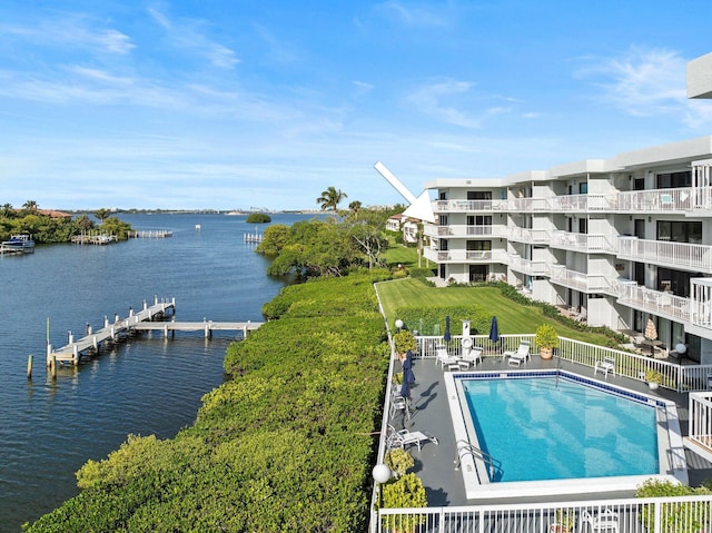 view of pool with a water view and a dock