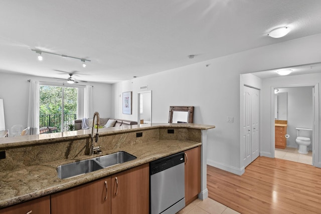 kitchen featuring stone counters, sink, stainless steel dishwasher, ceiling fan, and light tile patterned floors