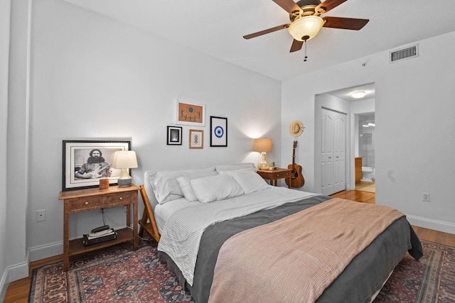 bedroom featuring ceiling fan, a closet, ensuite bathroom, and wood-type flooring