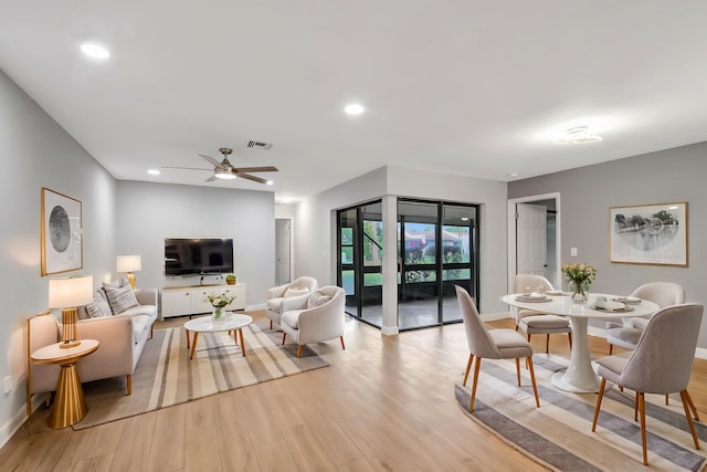 living room featuring ceiling fan and light wood-type flooring