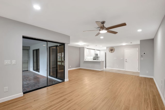 unfurnished living room with ceiling fan and light hardwood / wood-style flooring