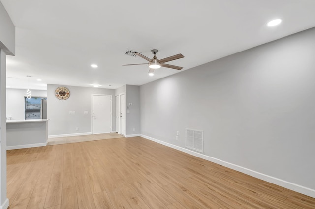 empty room with ceiling fan and light hardwood / wood-style floors