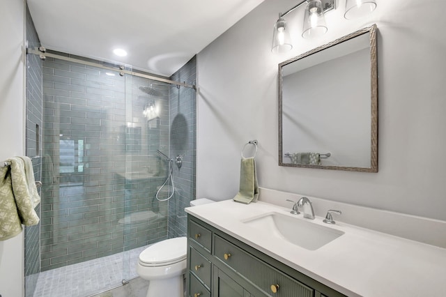 bathroom with vanity, toilet, and a shower with door