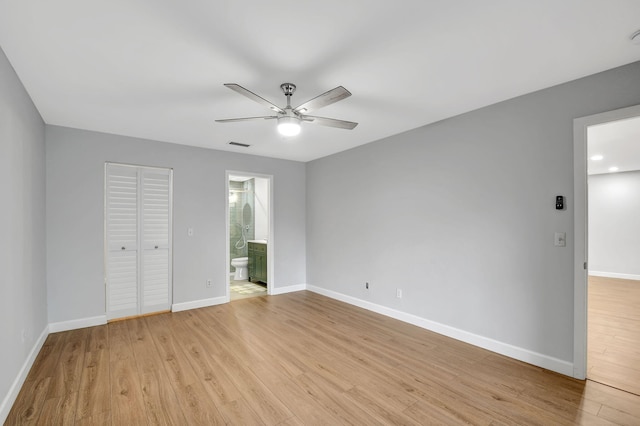 unfurnished bedroom with a closet, light hardwood / wood-style floors, ceiling fan, and ensuite bath