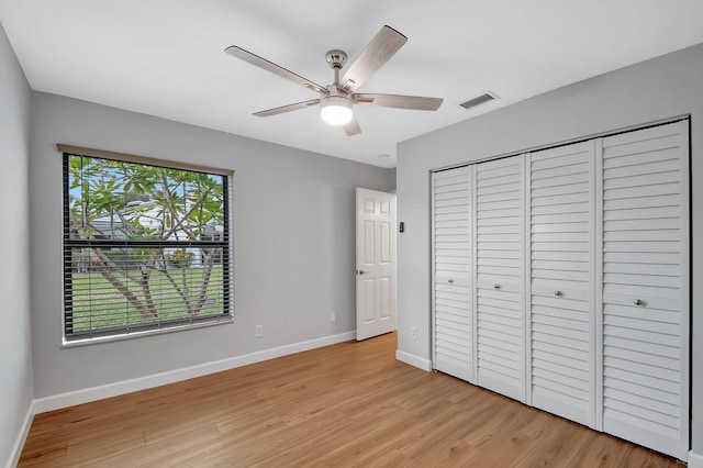 unfurnished bedroom with ceiling fan, a closet, and light wood-type flooring