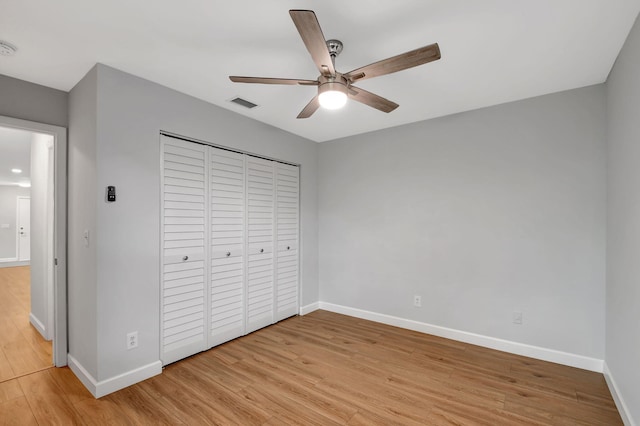 unfurnished bedroom with a closet, ceiling fan, and light wood-type flooring