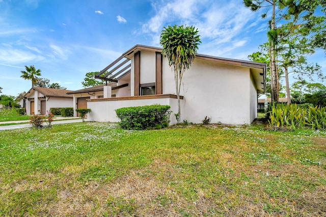 view of side of home featuring a yard and stucco siding