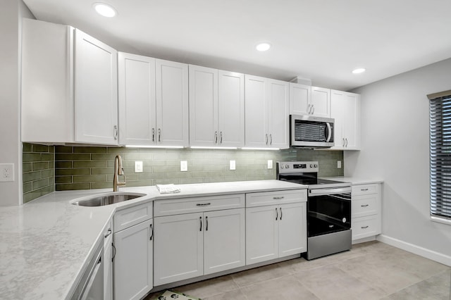 kitchen with white cabinets, backsplash, sink, and appliances with stainless steel finishes