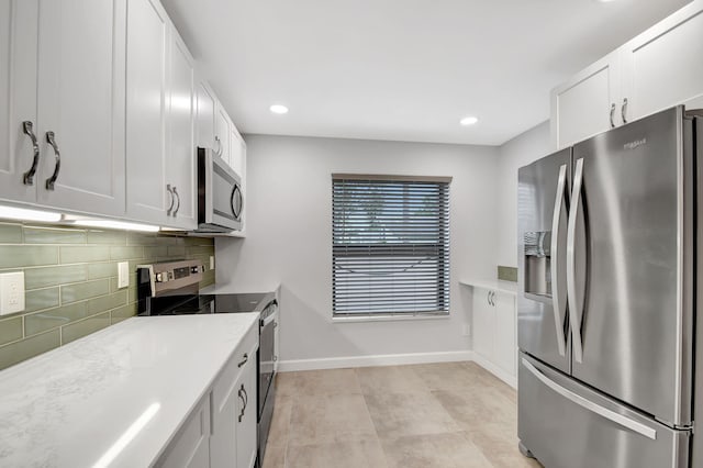 kitchen featuring light stone counters, white cabinetry, appliances with stainless steel finishes, and tasteful backsplash