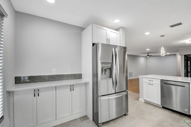 kitchen with kitchen peninsula, appliances with stainless steel finishes, ceiling fan, pendant lighting, and white cabinetry