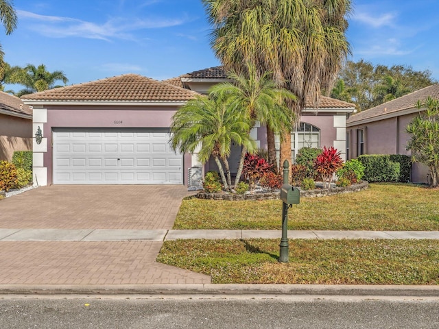 6604 Southport Dr, Boynton Beach, FL 33472 - mediterranean / spanish house featuring a front yard and a garage