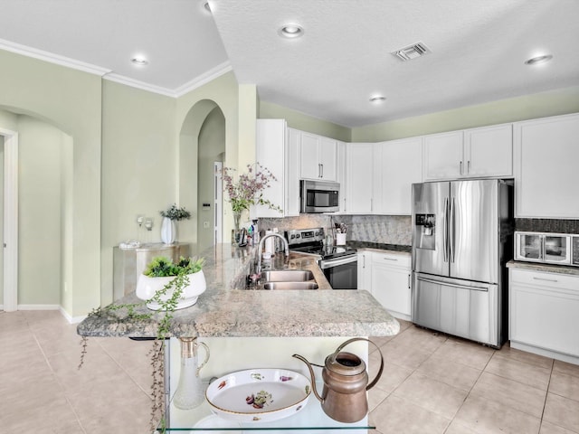 kitchen featuring sink, stainless steel appliances, kitchen peninsula, a breakfast bar, and white cabinets