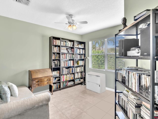 living area with light tile patterned floors, a textured ceiling, and ceiling fan